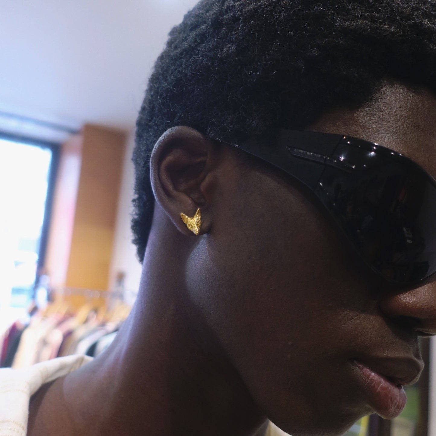 Fox stud earrings worn on the ear, minimalist animal jewelry in gold-plated sterling silver.