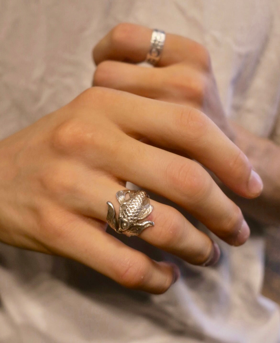 Sterling silver goldfish ring worn on a man’s hand – handcrafted animal jewelry from Paris, detailed koi-inspired design symbolizing tranquility and movement.