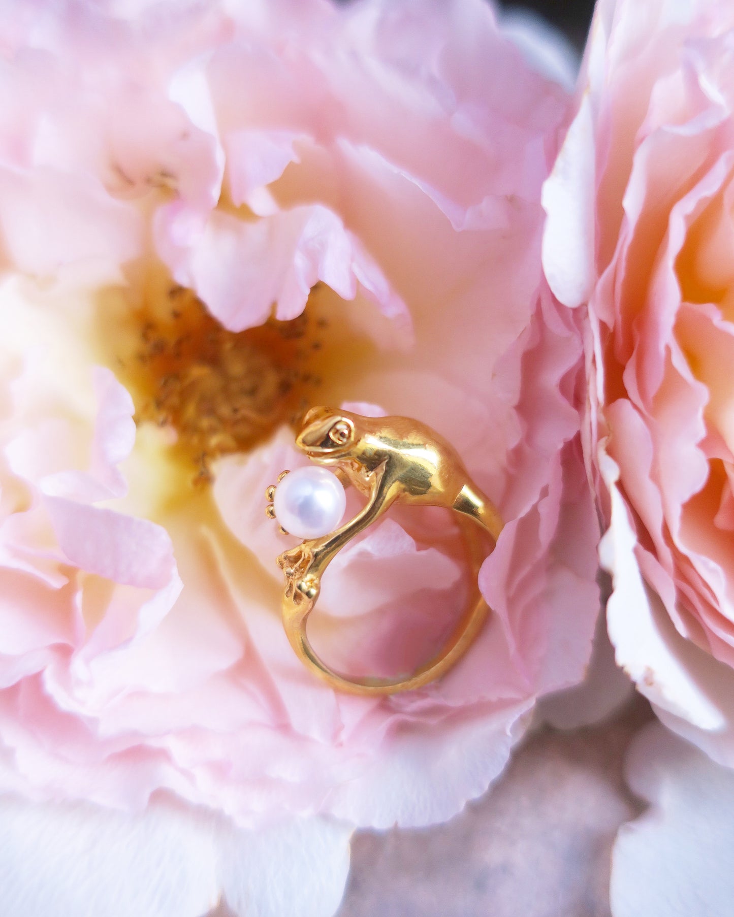 Gold-plated silver frog ring with a freshwater pearl nestled in pink petals, Art Nouveau-inspired handmade animal jewelry.