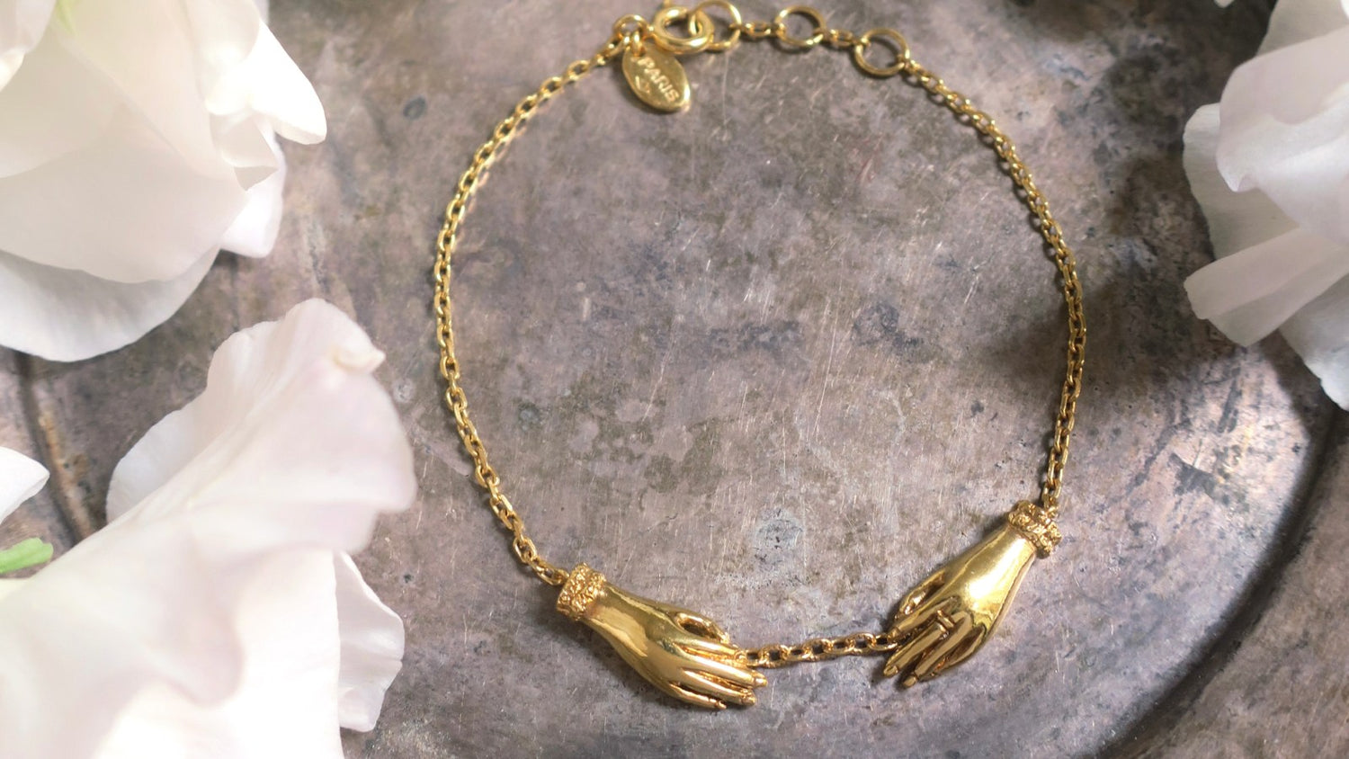 Gold-plated silver bracelet featuring two sculpted hands joined together — handcrafted designer jewelry from Paris inspired by antique motifs, artisan animal-themed and botanical collections