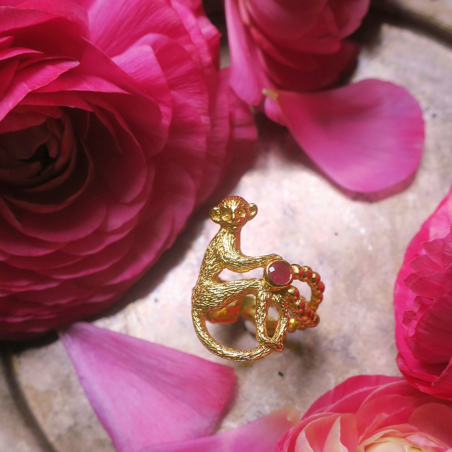 18K gold-plated silver 925 monkey ring with opaque rough-cut ruby styled on an antique tray with pink flowers
