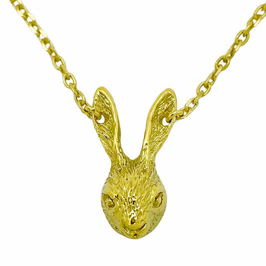 Close-up of a tiny rabbit necklace in gold-plated sterling silver, featuring a finely sculpted rabbit head with detailed ears and textured surface, handmade artisan animal jewelry.