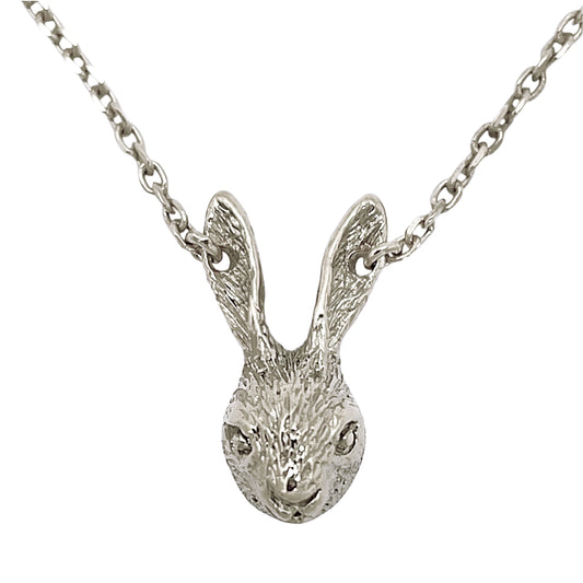 Close-up of a tiny rabbit necklace in sterling silver, featuring a finely sculpted rabbit head with textured surface and a distinctive chain passing through the ears.