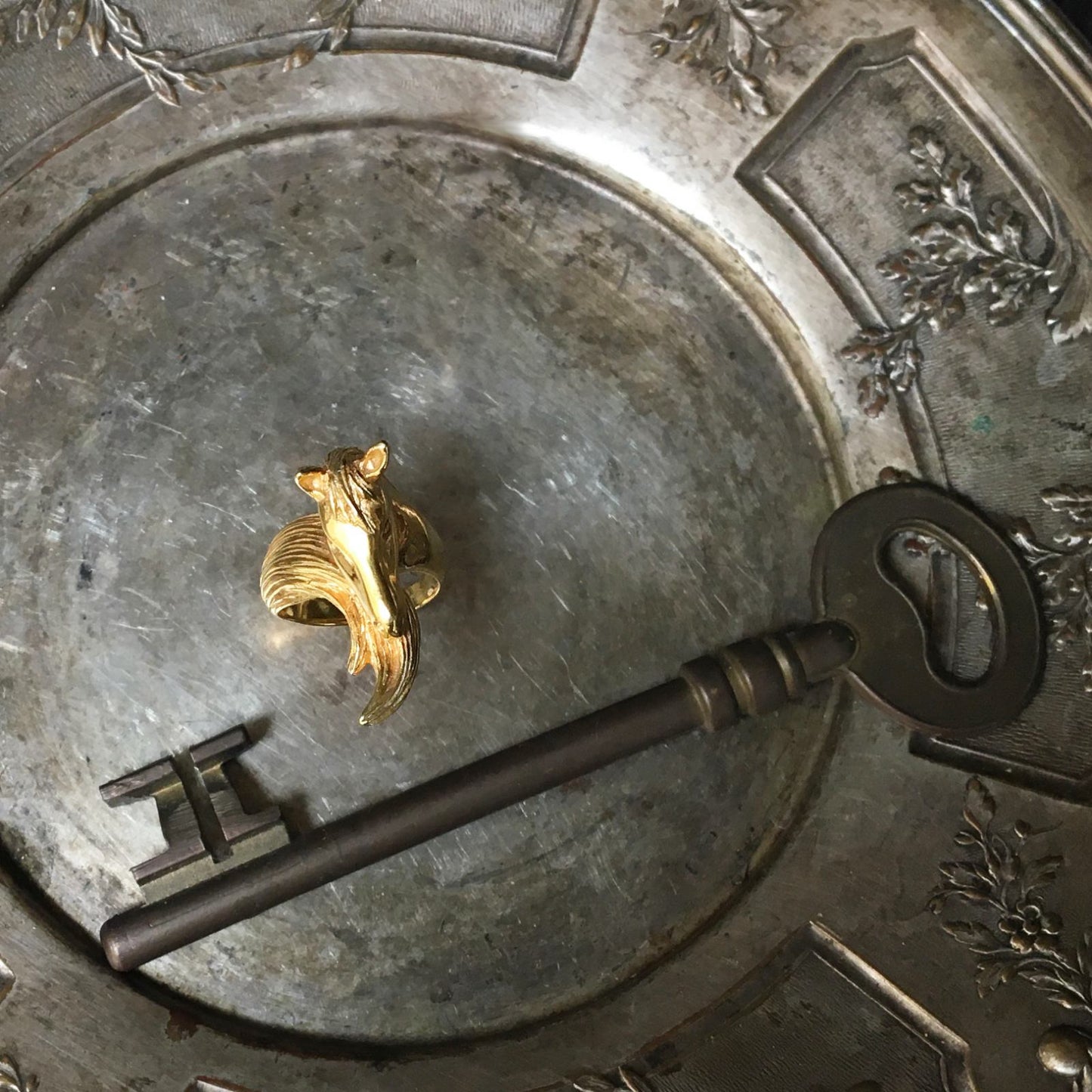 Horse motif ring in 18K gold-plated sterling silver styled on antique tray, artisanal animal jewelry with strong sculptural presence and polished finish.