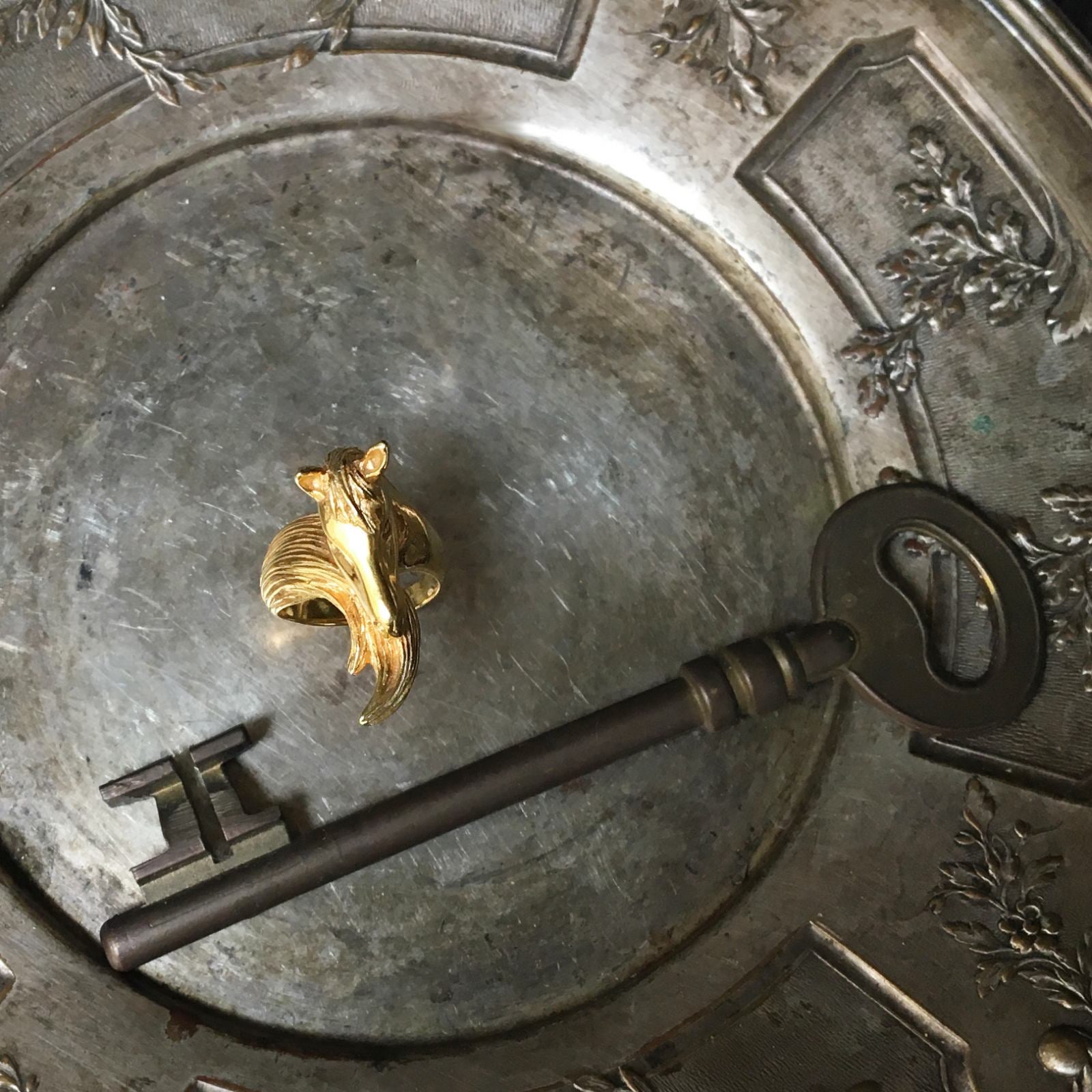 Horse motif ring in 18K gold-plated sterling silver styled on antique tray, artisanal animal jewelry with strong sculptural presence and polished finish.