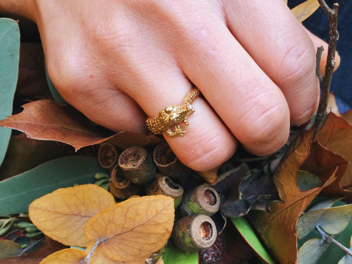Hand-sculpted gold-plated silver crocodile ring on a woman’s hand. Artisan animal jewelry made in Paris.