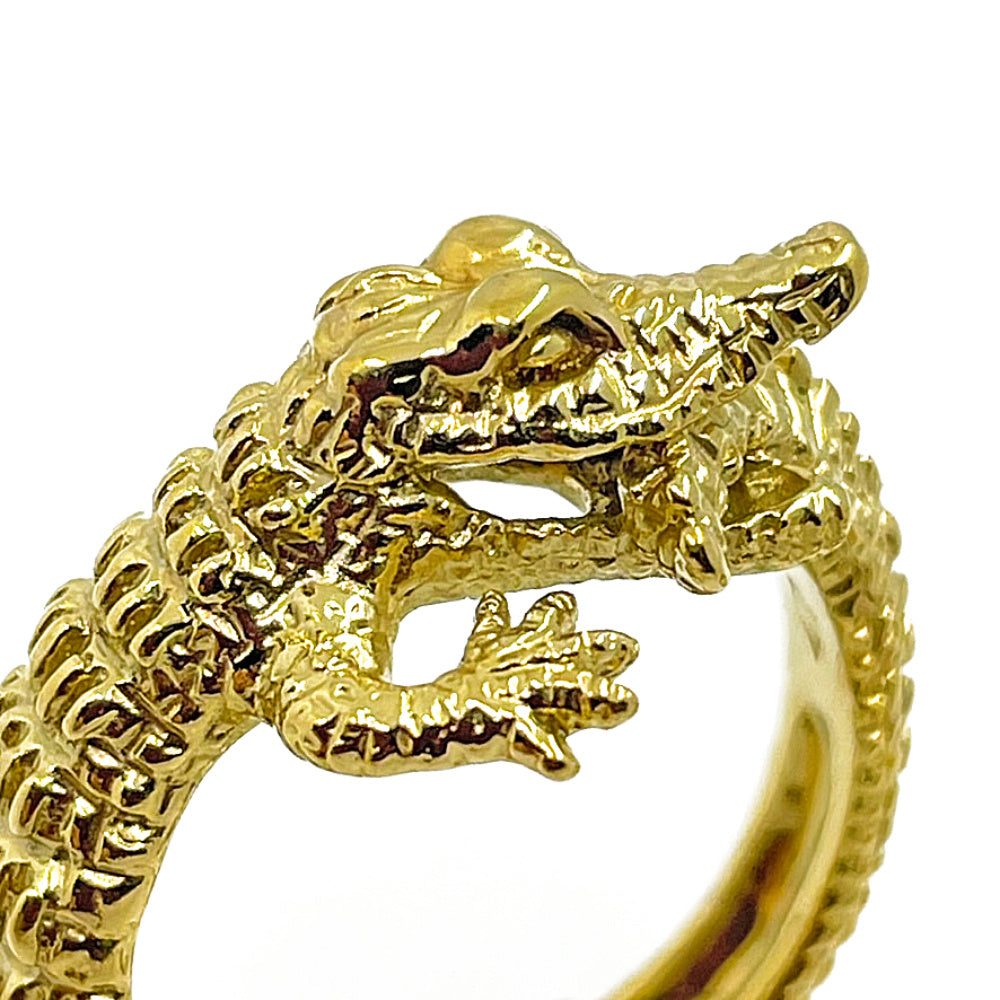 Close-up of hand-carved crocodile ring in 18K gold-plated silver, showing engraved scales, claws, and reptile texture