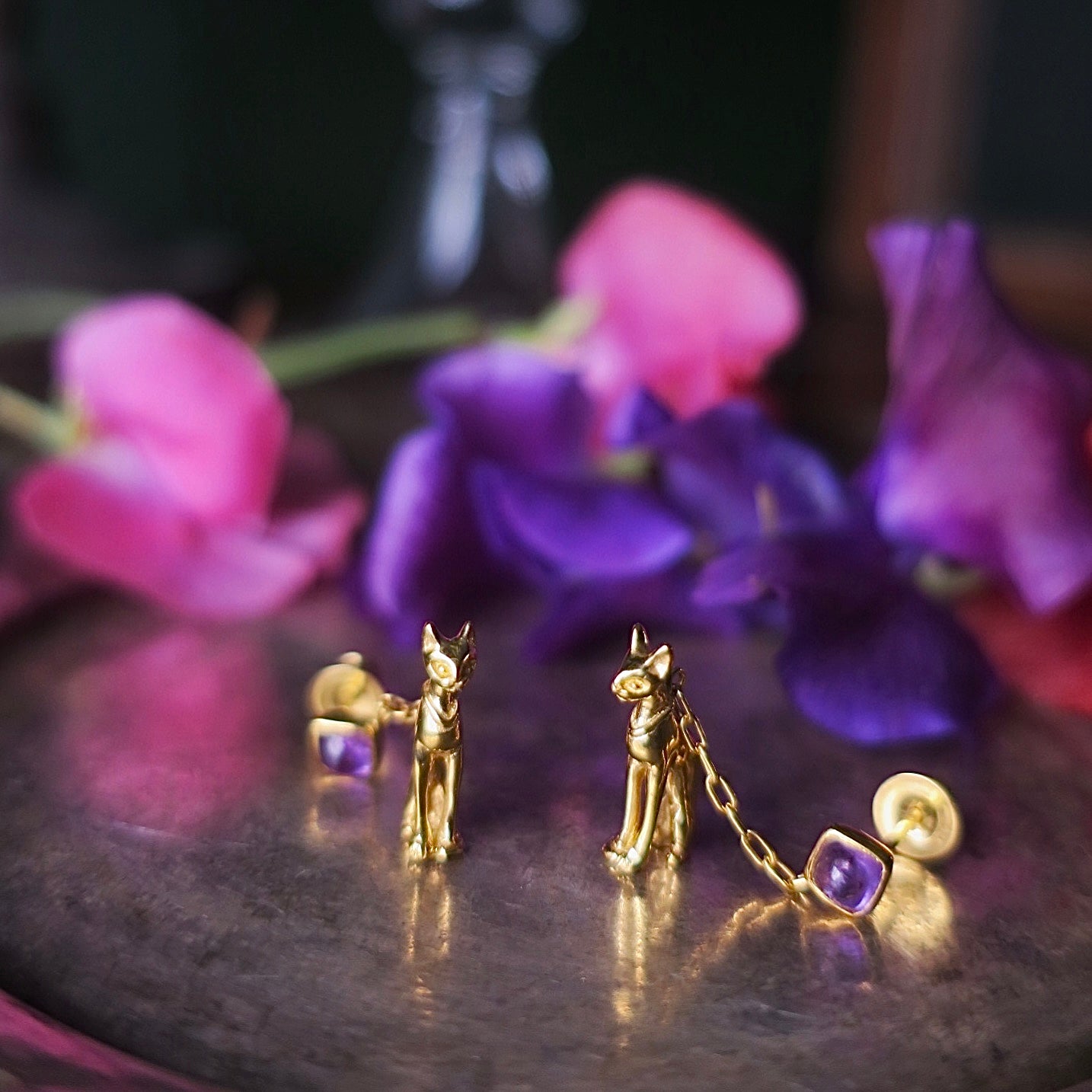 18K gold-plated silver 925 Egyptian cat earrings with natural amethysts styled standing upright among purple flowers