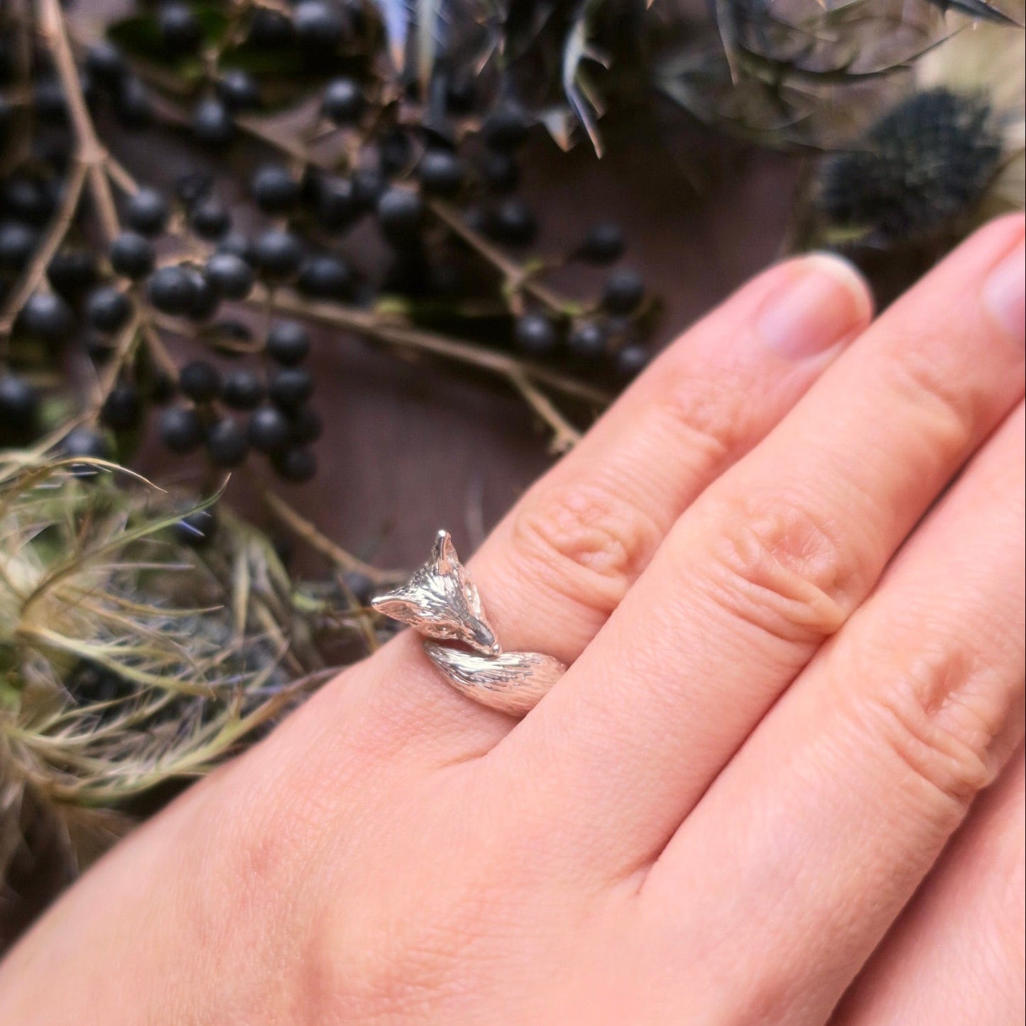 Hand wearing silver fox pinky ring on little finger, bold animal motif ring with three-dimensional sculpted fox form