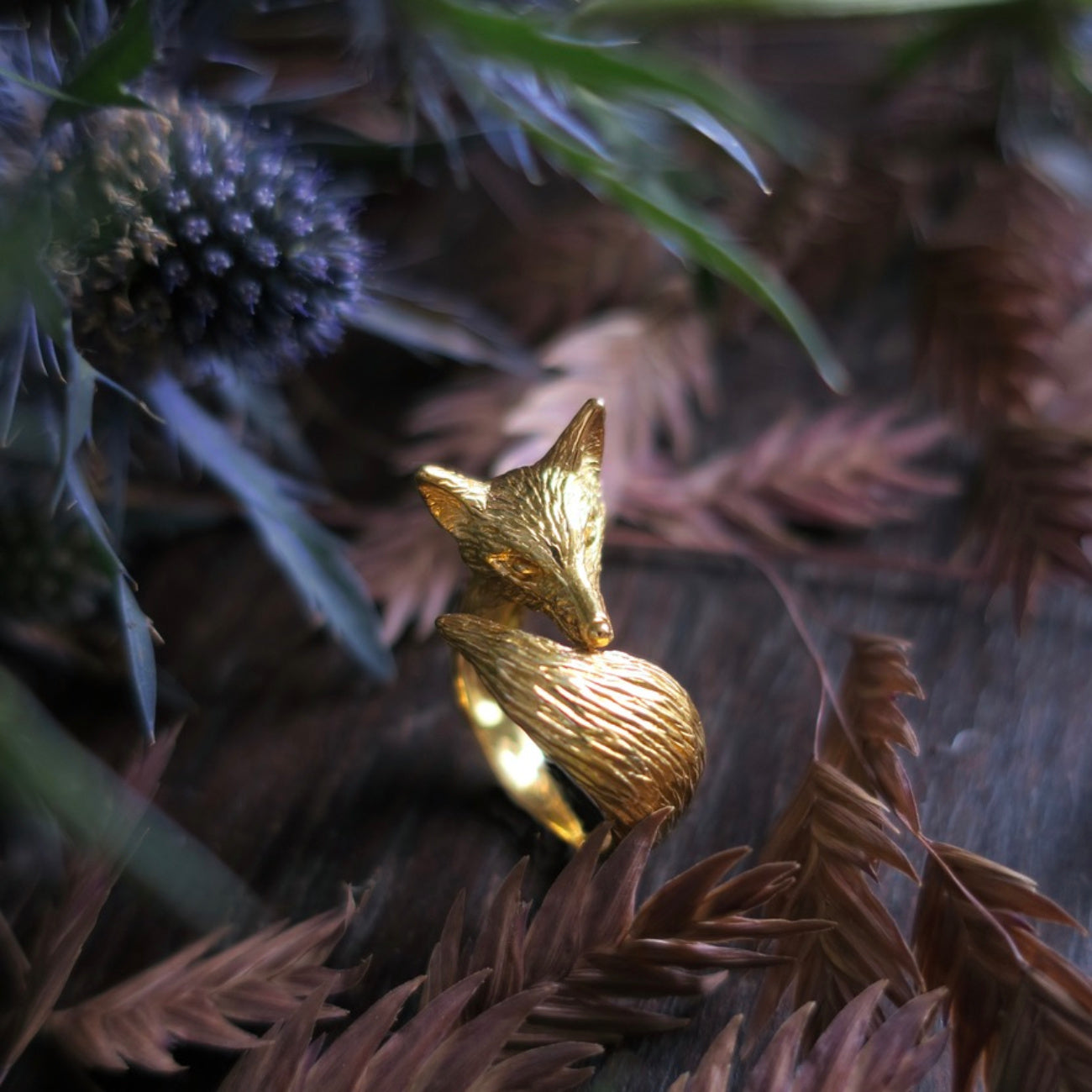 Fox ring in gold-plated silver 925 placed among leaves, curled fox shape with textured fur