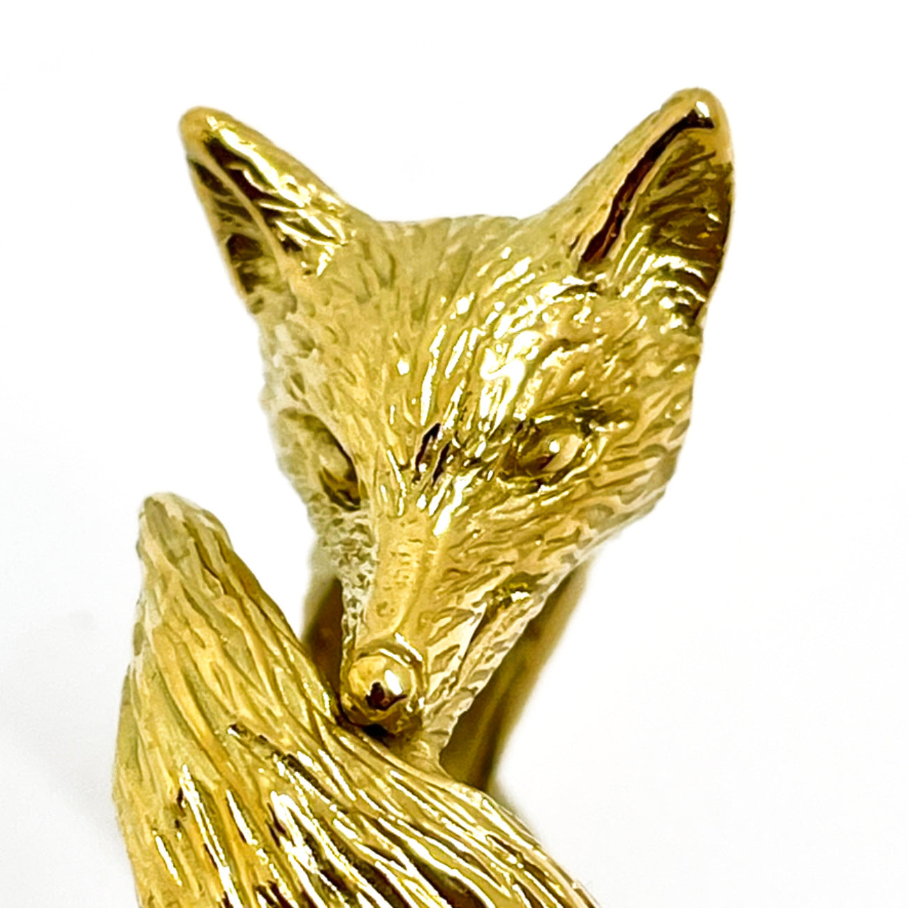 Close-up of hand-carved fox face on 18K gold plated silver ring, detailed fur texture and expression