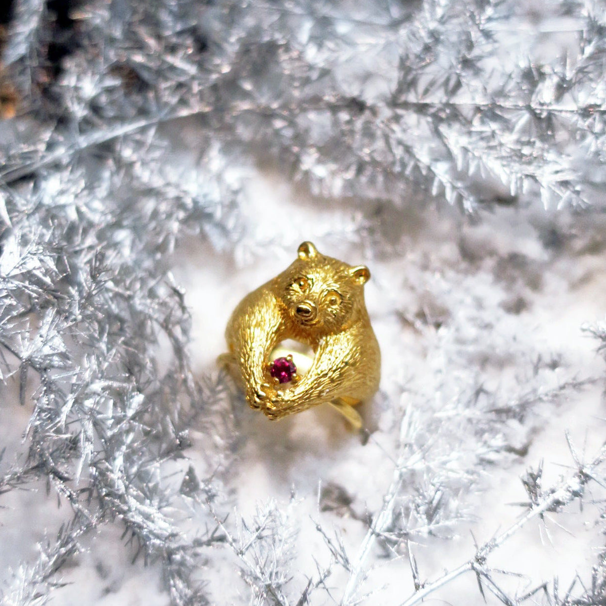 Bear ring in 18K gold-plated silver 925 layered with a garnet solitaire ring on snow