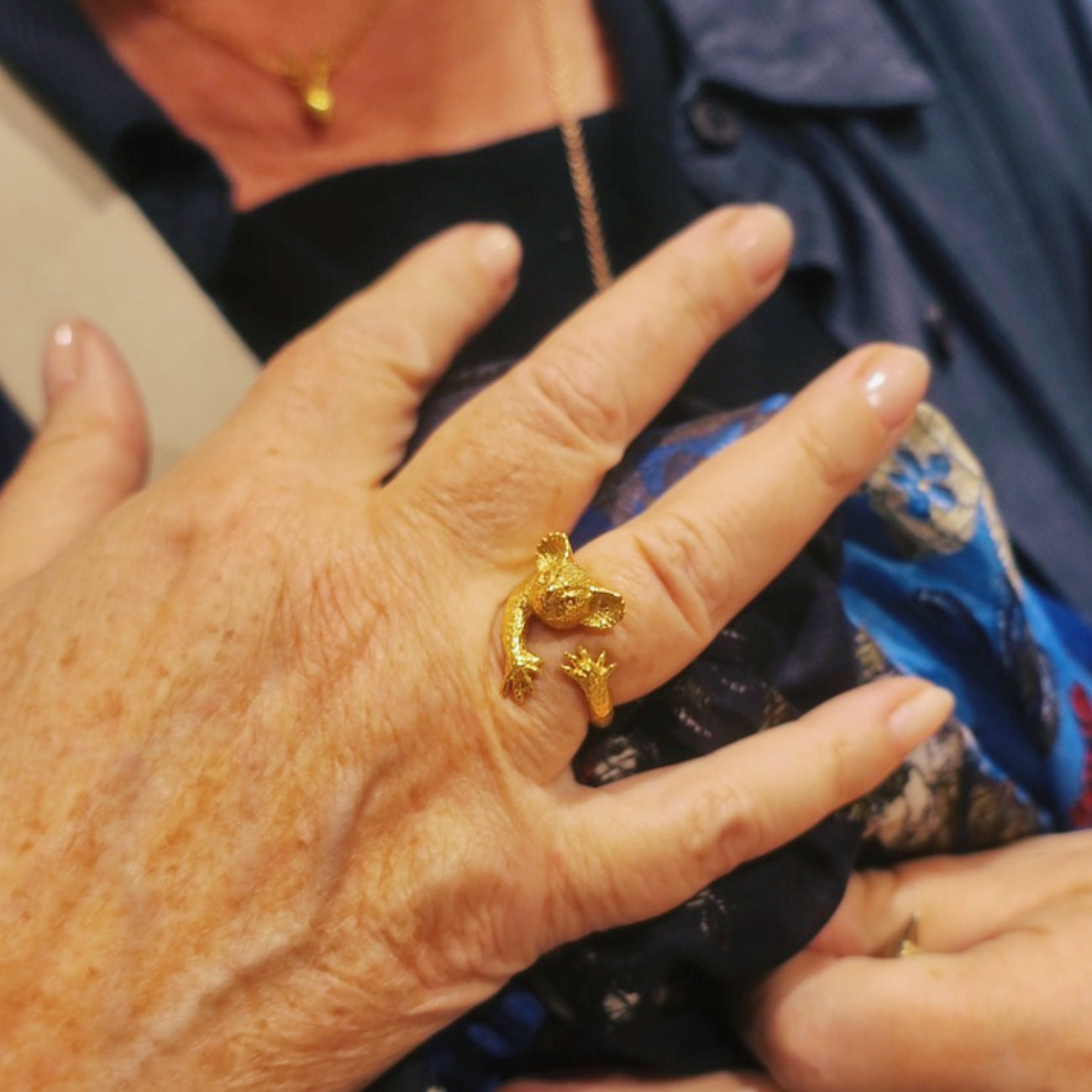 Koala ring in 18K gold-plated silver 925 worn on hand, hugging pose showing animal ring in context