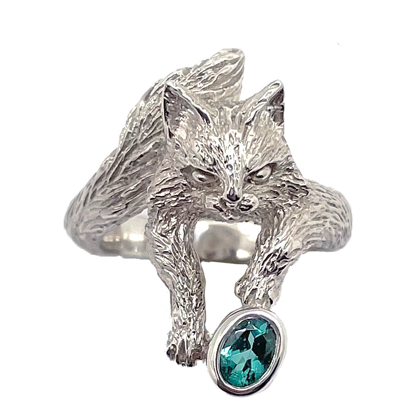 Maine Coon cat ring in sterling silver, featuring a long-haired cat holding a natural blue tourmaline with subtle green tones, sculptural animal jewelry.