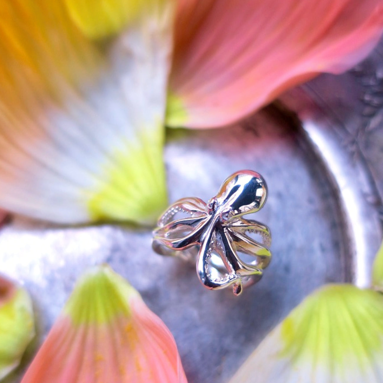 Sterling silver octopus ring on antique metal plate with flowers, detailed tentacles and organic sculpted shape
