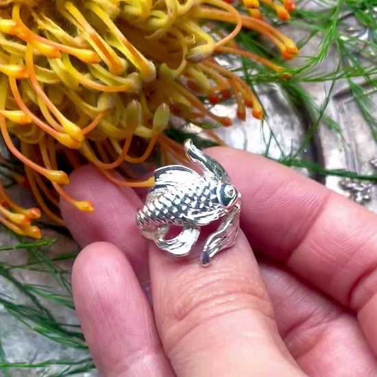 Detail of carved silver goldfish ring in video.