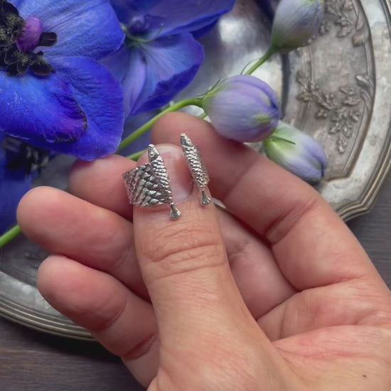 Video of silver 925 fish ring rotating in hand, sculptural open ring showing full design and finely engraved scale details