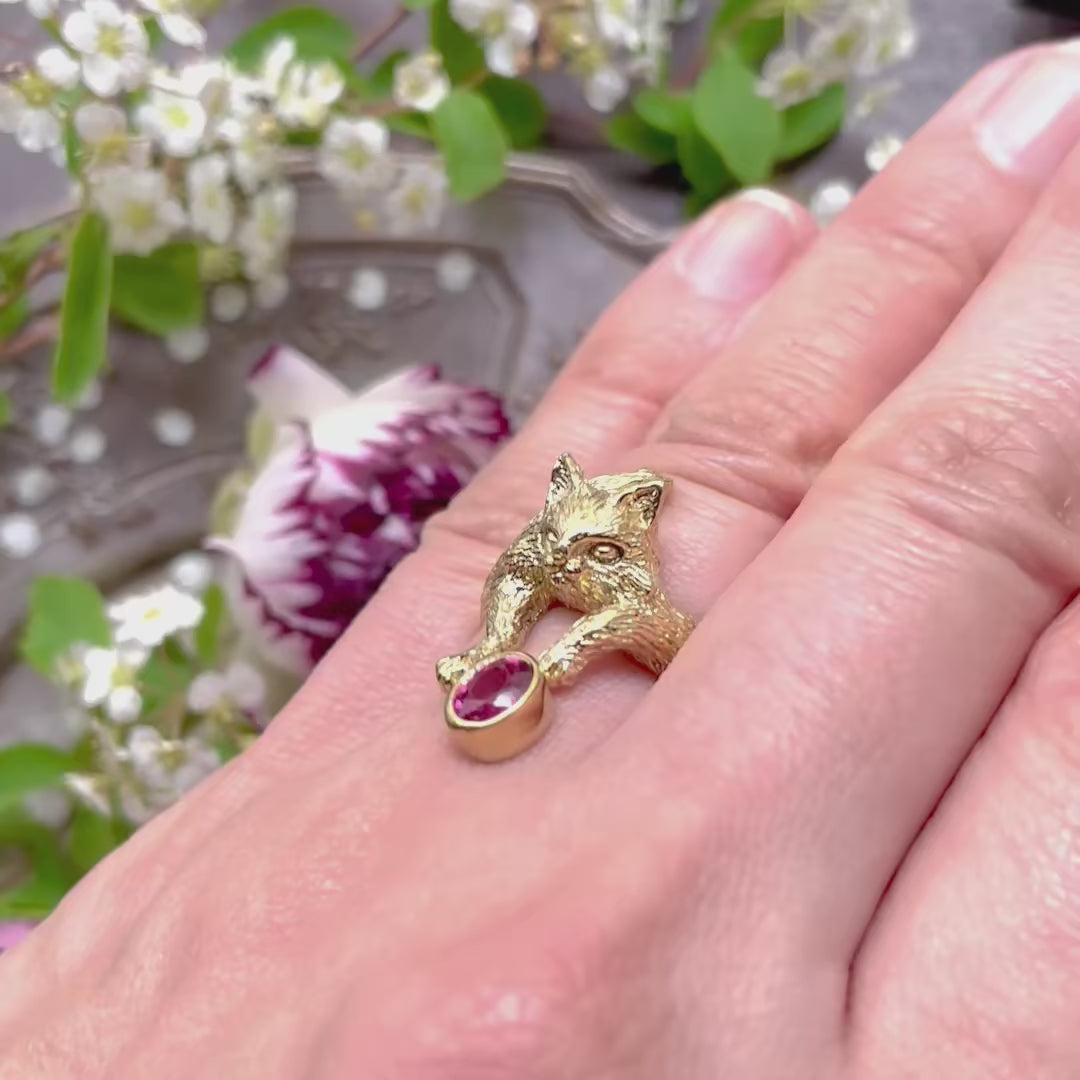 Video of Maine Coon cat ring worn on finger, natural light highlighting the sparkle of the oval-cut pink tourmaline