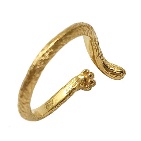 Close-up side view of a cat tail ring in 18K gold-plated silver, showing the sculpted paw pad on the underside and detailed fur texture. Handcrafted cat-themed jewelry by a Paris artisan.
